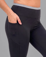 Close-up of Black High-Rise Leggings with a hand in the deep side pocket, below the grey waistband.