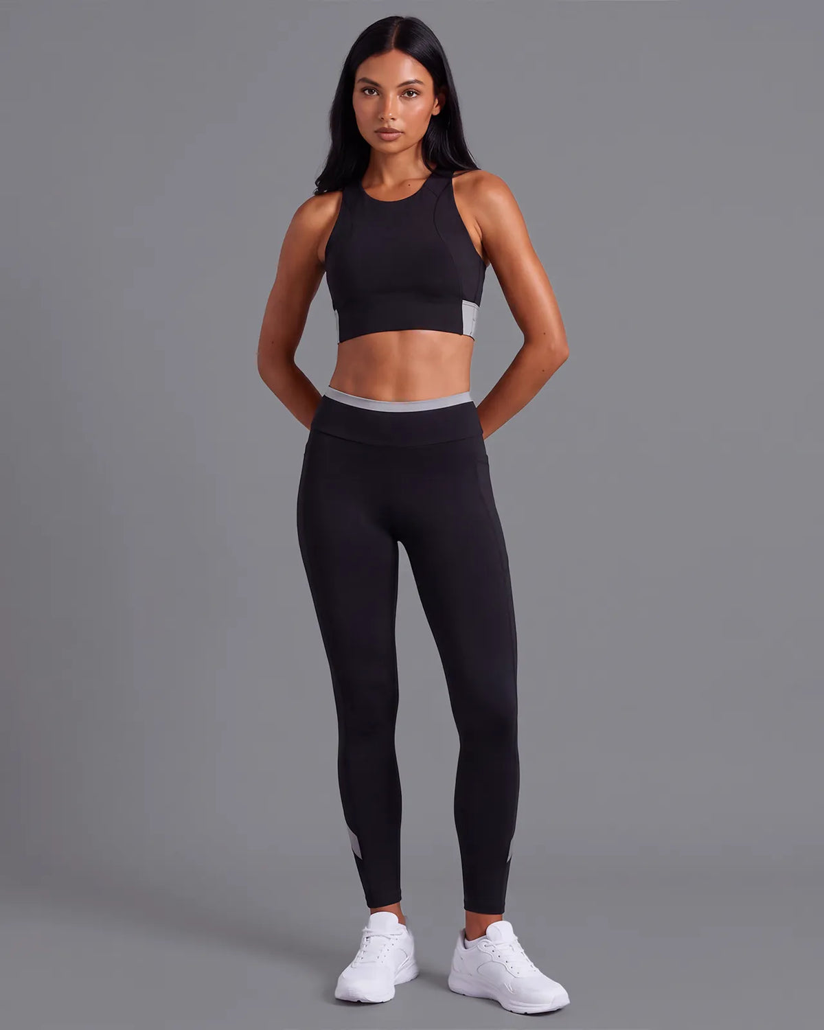 Full-length front view of a model in the Black Full Coverage Sports Bra and High-Rise Leggings with a grey waistband.