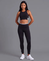 Full-length front view of a model in the Black Full Coverage Sports Bra and High-Rise Leggings with a grey waistband.