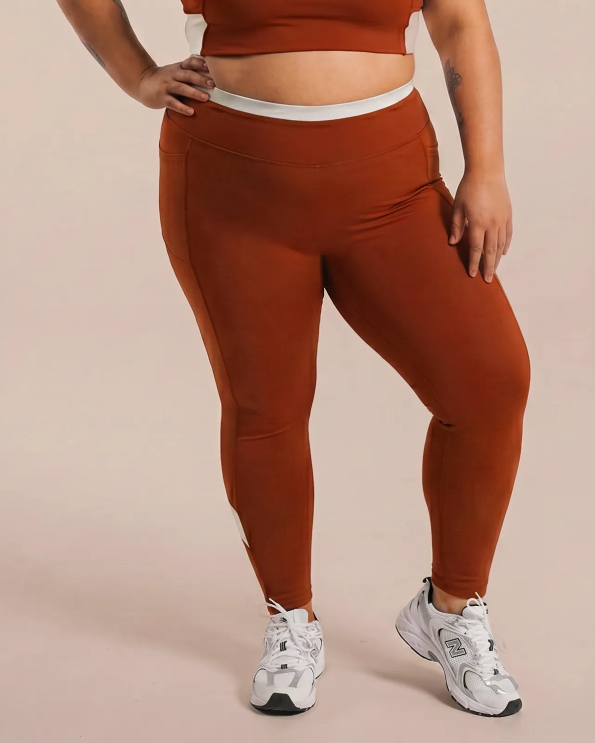 Front view of Brown High-Rise Leggings with no front seam, a cream waistband and calf panels.