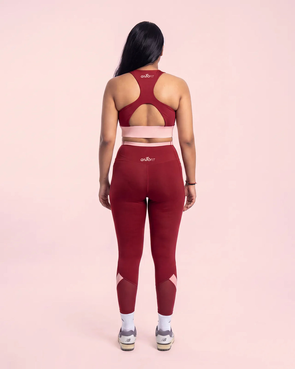 Full-length back view of the Maroon sports bra and leggings, showing the racerback construction, keyhole opening and fit through the hips.