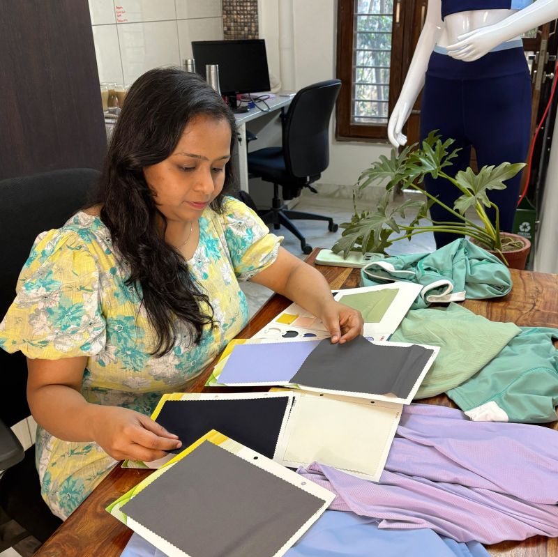 QivoFit founder reviewing nylon and polyester fabric samples for OEKO-TEX® certified activewear development during 15 months of product development with 50+ suppliers