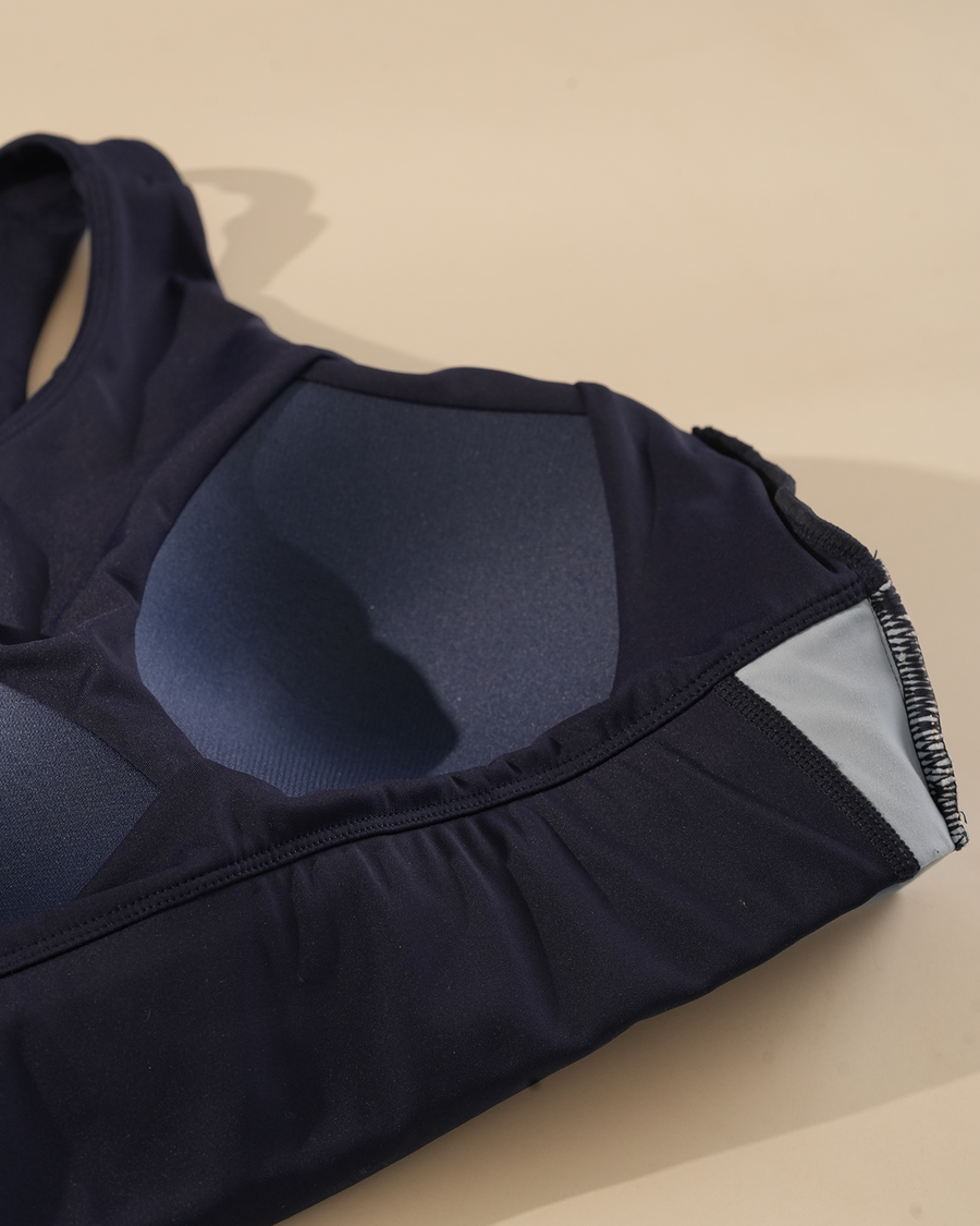 Inside of a black QivoFit sports bra laid flat, showing the moulded built-in cups.