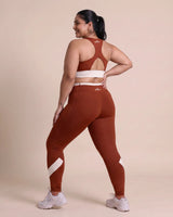Full-length back view of the Brown sports bra and leggings, model looking over her shoulder, showing the racerback construction and fit through the hips.