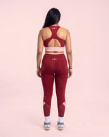 Full-length back view of the Maroon sports bra and leggings, showing the racerback construction, keyhole opening and fit through the hips.