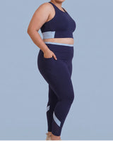Side view of Navy High-Rise Leggings with a hand tucked into the deep side pocket.